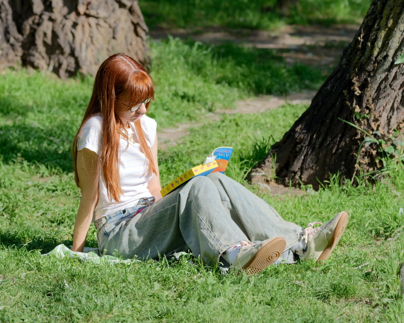 Girl reading a book in the grass